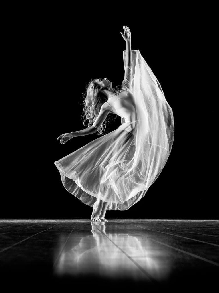 La bailarina en el escenario, Pies-en-punta fluyendo con el ritmo de la música.
